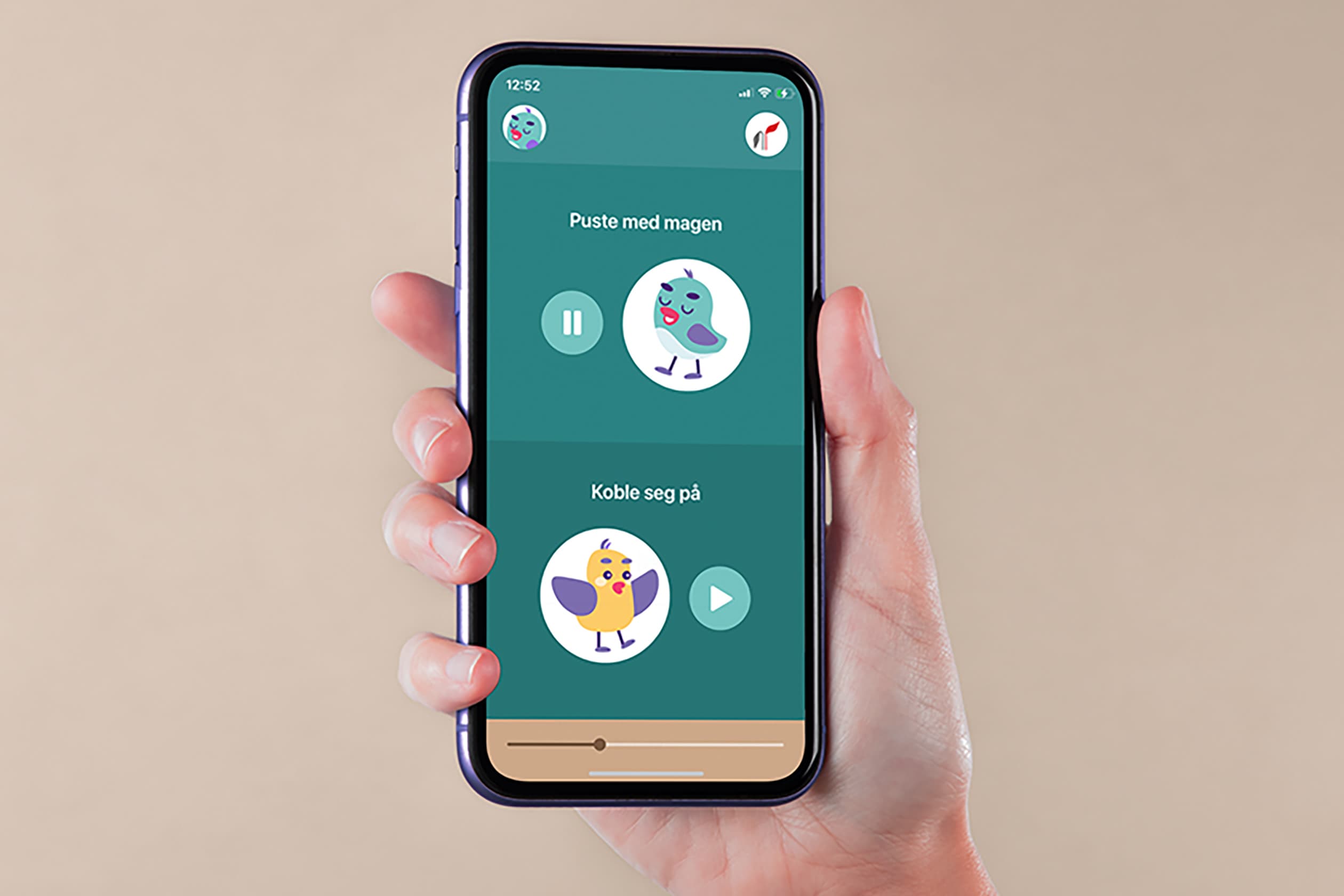 En hånd holder en smarttelefon som viser en app med lekne fugleillustrasjoner, knapper for avspilling og pause, og tekst på norsk på grønn bakgrunn. Klokken på telefonen er 12:52.